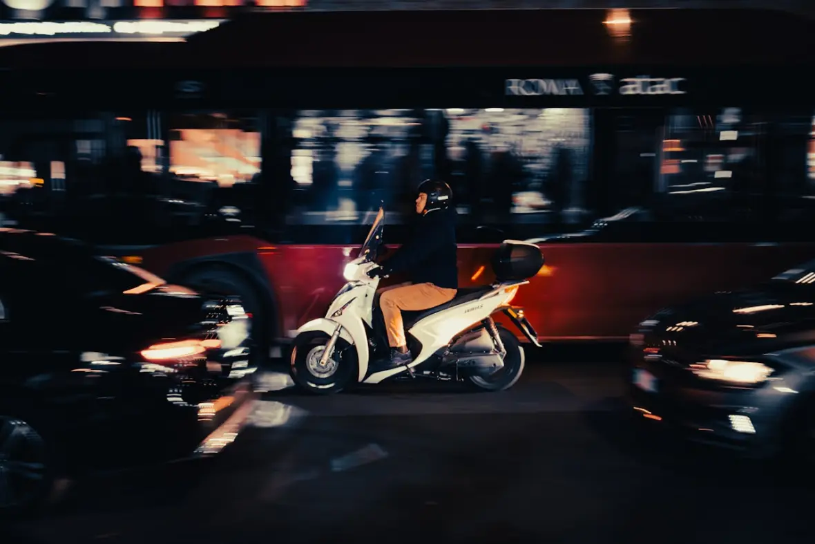 Rollerfahrer fährt am Abend durch den Stadtverkehr
